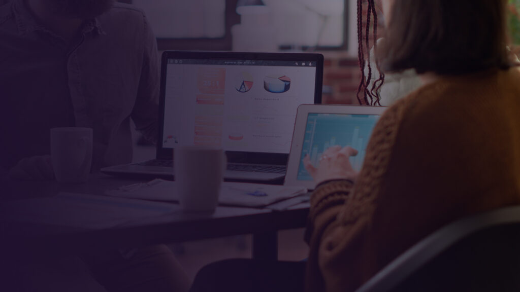 Especialistas da Fenicio analisando dashboards de RevOps em notebook e tablet para integração de métricas de vendas e marketing.