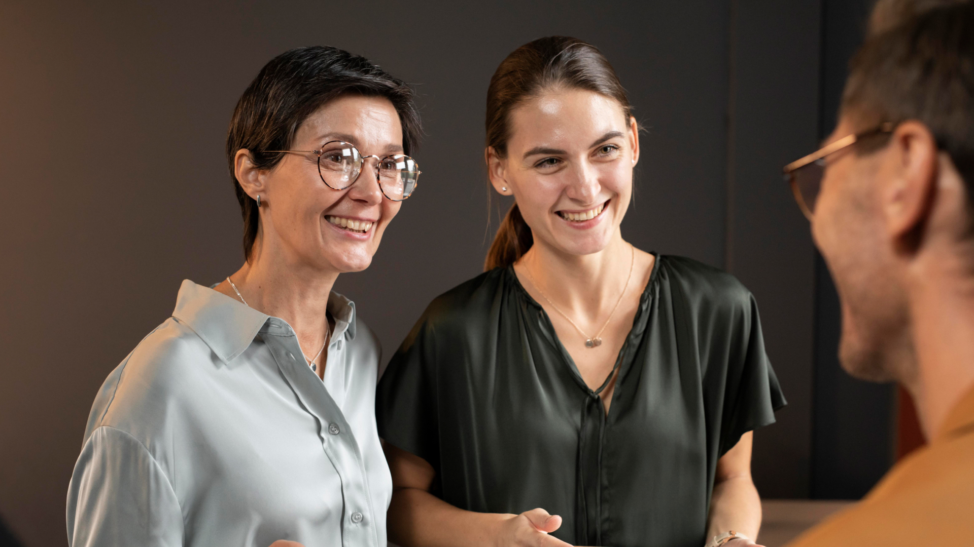 Consultoras da Fenicio sorridentes durante sessão de mentoria e feedback em treinamento corporativo personalizado.