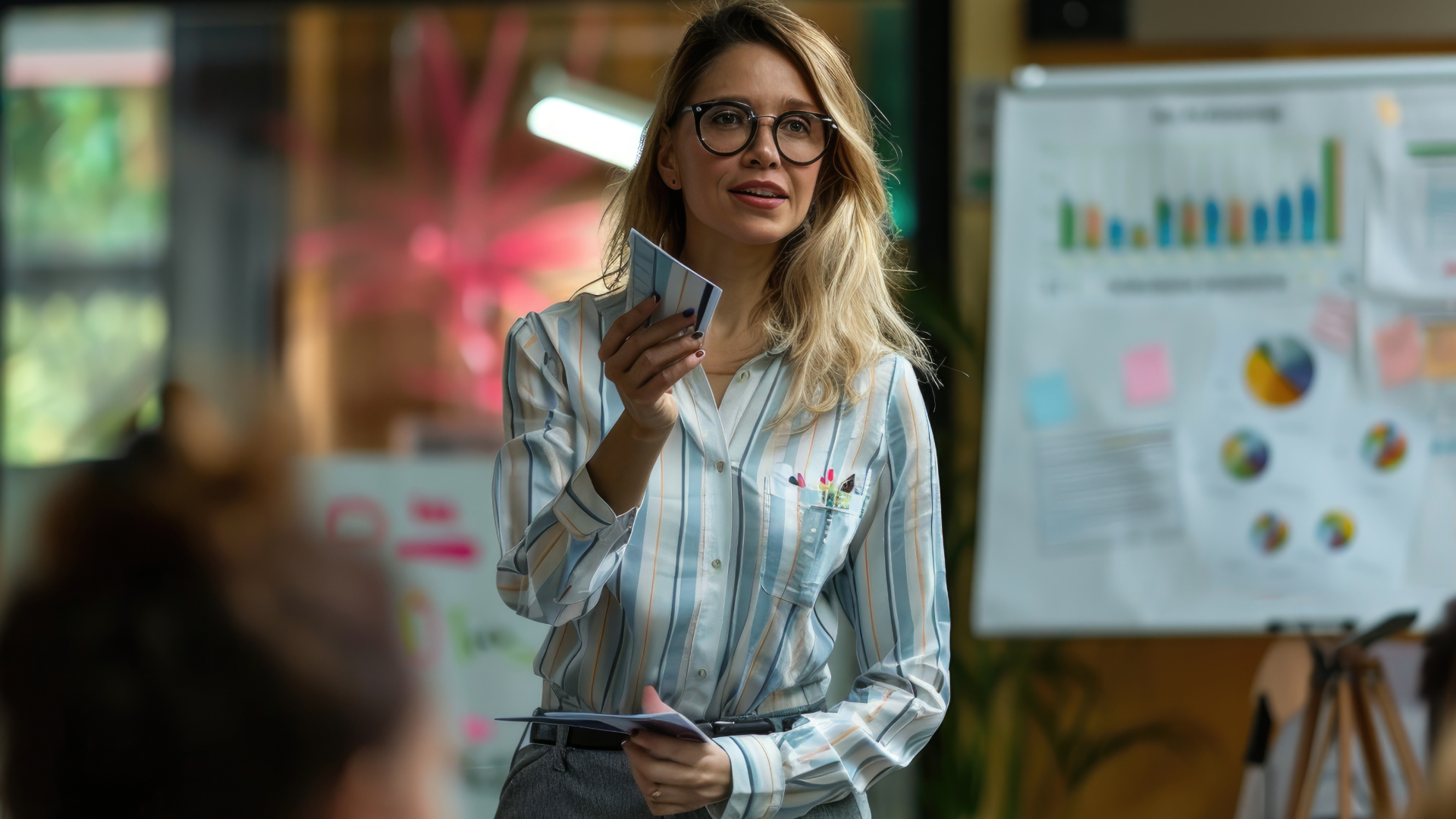 Consultora da Fenicio utilizando cartões de suporte didático durante treinamento de análise de métricas e KPIs para gestores.