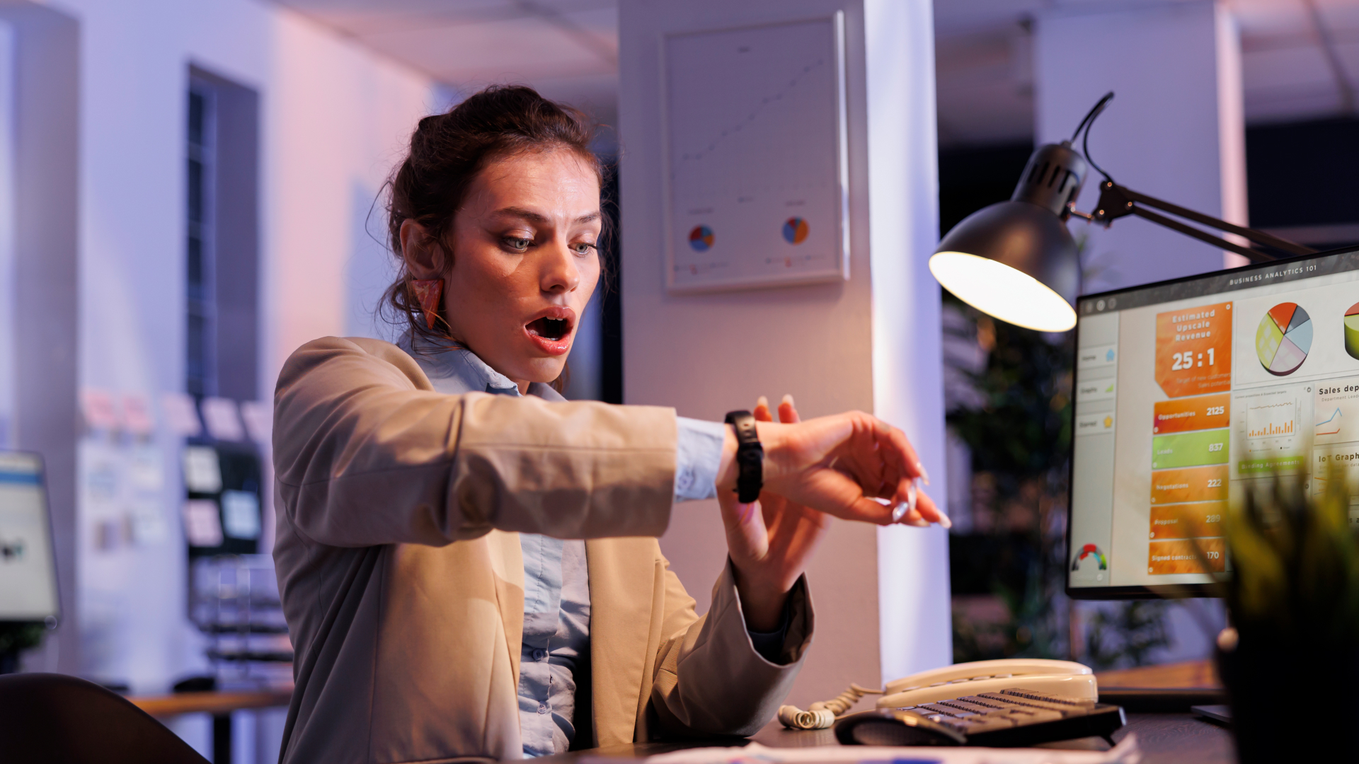 Gestora surpresa com o horário no smartwatch enquanto analisa dashboards de métricas, representando a urgência em otimização de processos e treinamentos de produtividade.