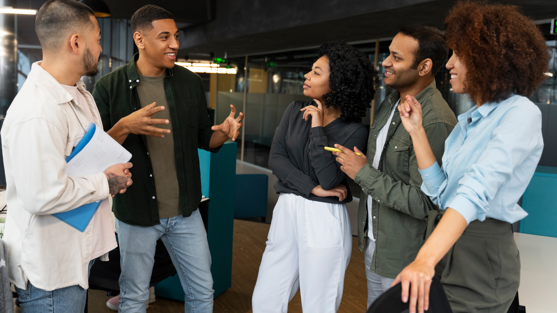 Grupo de profissionais engajados em dinâmica de treinamento da Fenicio, discutindo estratégias e compartilhando ideias em escritório moderno.